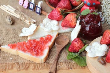 Fresh strawberries red and jam with bread.