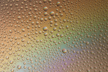 Naklejka premium macro shot of liquid droplets with reflection. color background with water drops texture. gradient color