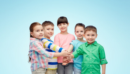 Fototapeta na wymiar happy little children with hands on top over blue