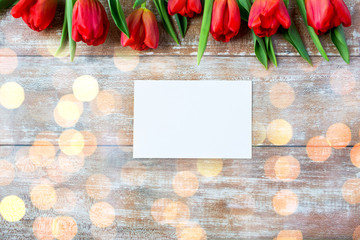 close up of red tulips and blank paper or letter