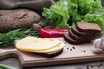 Fototapeta na wymiar cheese and bread on the table and fresh herbs