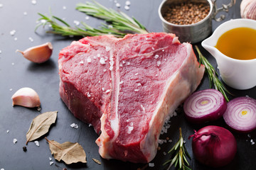 Raw fresh meat t-bone steak with spices, garlic and rosemary - 104178845