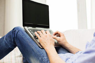 close up of man typing on laptop computer at home