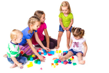 Happy kids playing with building blocks isolated on white