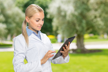 Beautiful smiling doctor woman in medical gown