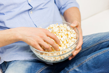 close up of man eating popcorn at home