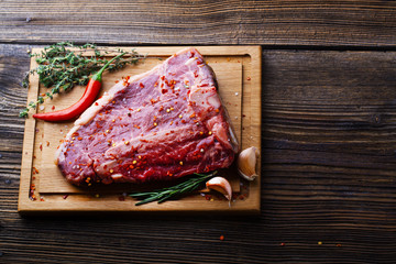 Raw fresh meat T-Bone Steak with herbs and spices and chilli pep
