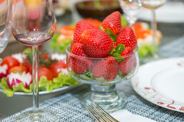 Glassware filled with strawberries on a table during dinner