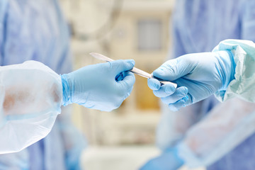 close up of hands with scalpel at operation