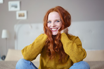 lachende frau mit langen roten haaren zu hause