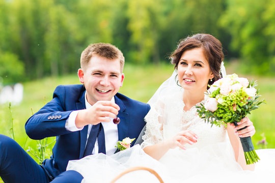 Happy young wedding couple on picnic in park