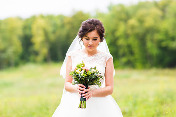 Young bride holding big wedding bouquet