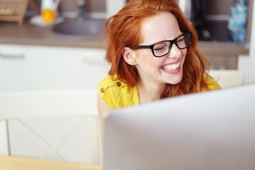 junge frau sitzt am pc und lacht