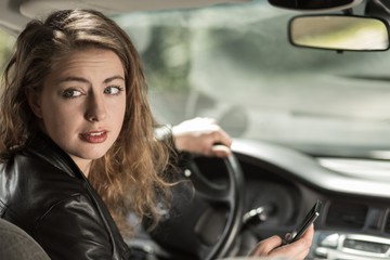 Fototapeta na wymiar Woman driving and texting