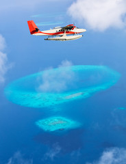 Fototapeta na wymiar Sea plane flying above Maldives islands