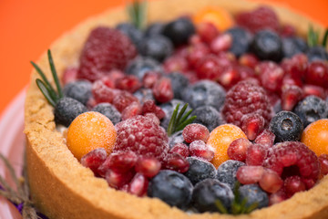 fresh berries on the cake cheesecake on a bright orange background