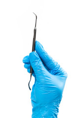 Gloved hand holding dental instrument