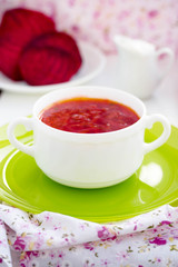 Red Ukrainian borsch soup with sour cream in a white plate.