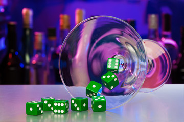 Cocktail glass with dices in casino bar