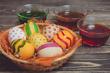 Easter eggs in basket on wooden boards