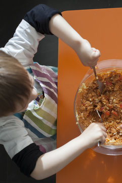 Child cooking pasta salad