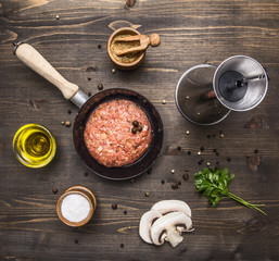 raw cutlet burger for a small frying pan, seasoning, butter, mushrooms, parsley on wooden rustic background top view close up