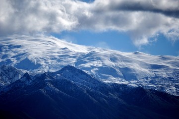 Fototapeta na wymiar snowy mountains , peaks and clouds