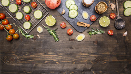 cherry tomatoes, lime, spices, cucumber, laid out on a chopping board, with peppers, herbs border ,place for text on wooden rustic background top view close up