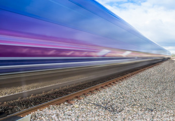 Close up of train speeding through English countryside with motion blur - 104187407