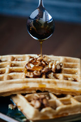 Waffles and honey on a wooden table