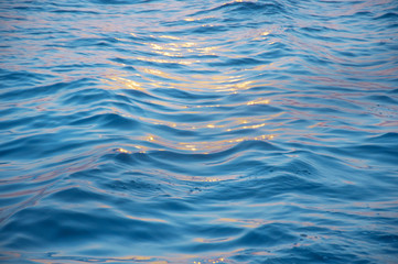 Yellow sunlight against close up sea wave surface
