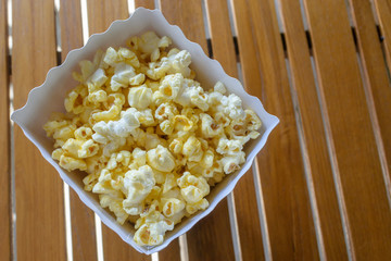 Popcorn in a container on wood table