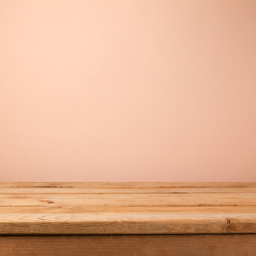 Empty wooden deck table over creamy wallpaper background