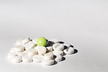 Green and white pills on a white background