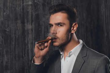 Close up portrait of pretty businessman smoking a sigar