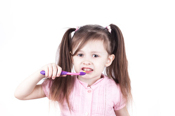 little child brushes her teeth, isolated on a white background