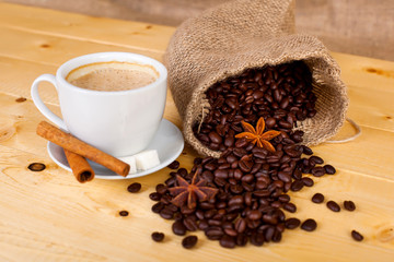 cup of coffee and coffee beans on a wooden surface