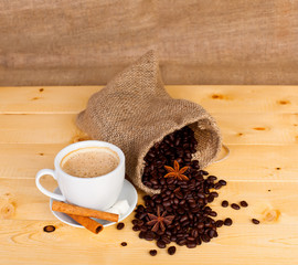 cup of coffee and coffee beans on a wooden surface