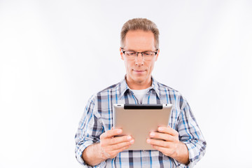 Handsome happy aged man in glasses holding tablet