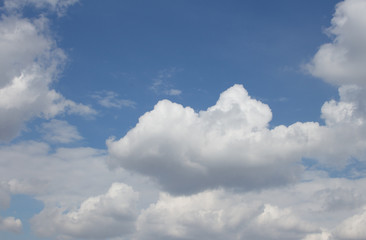 Fototapeta na wymiar White puffy clouds on the background blue sky