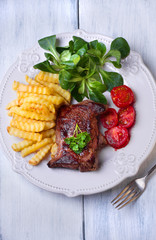 Grilled steak, French fries and vegetables
