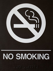 NO SMOKING sign in white letters on black background