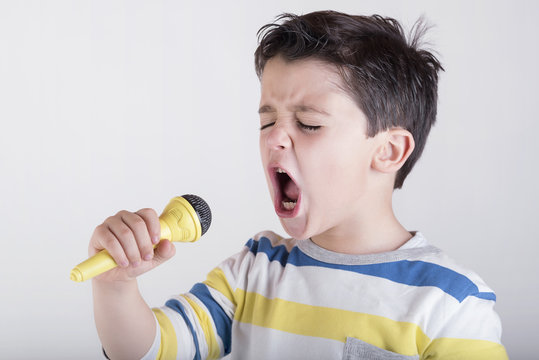 ni&ntilde;o cantando con un micr&oacute;fono 