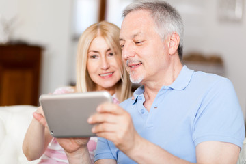 Couple using a tablet on the sofa