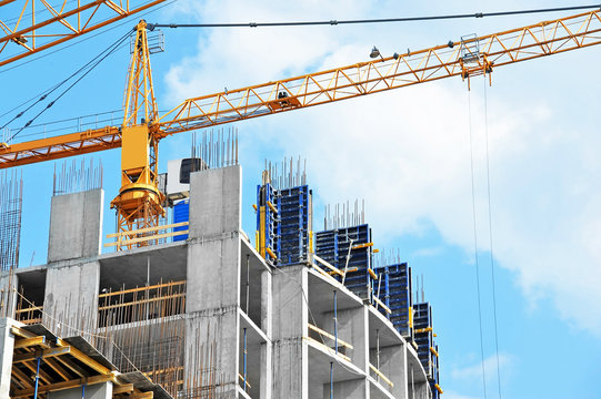 Crane And Building Construction Site Against Blue Sky