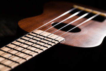 Close up of ukulele on wooden background.