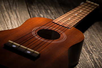 Fototapeta premium Close up of ukulele on wooden background.