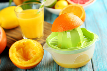 Citrus fruits with juicer on a blue wooden table