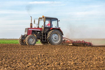Fototapeta premium Farmer cultivating arable land before seeding