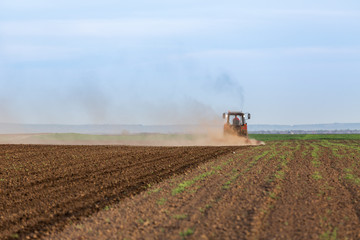 Farmer cultivating arable land before seeding
